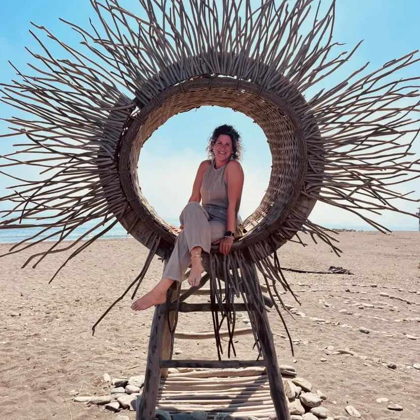 Anouk van den Berg sitting at the beach inside a round sun made out of wood